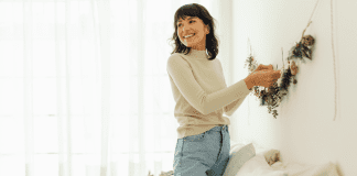 A woman putting up decorations for Christmas.