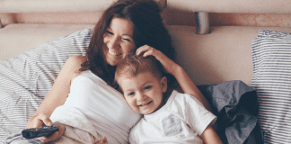 In Defense of Starting the New Year With a “Meh” Attitude A mother watching TV cuddled with her son.