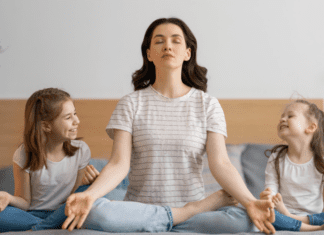 A mom meditating with her daughters.