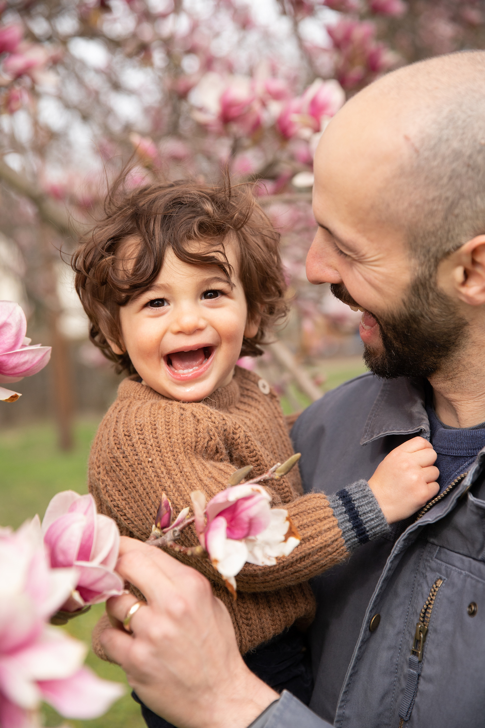 A father holding his son with a flower in his hand.