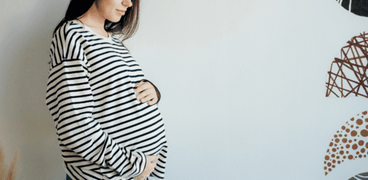 A pregnant woman holding her belly.
