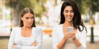 Toxic Women A jealous woman glaring at another woman on her phone.