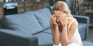 A mom holding her face experiencing a mom's guilt.