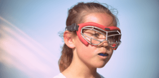 It’s a Hard Knock Life…for Girls in Sports A young girl lacrosse player wearing googles.
