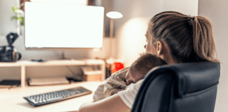 A working mom holding an infant.
