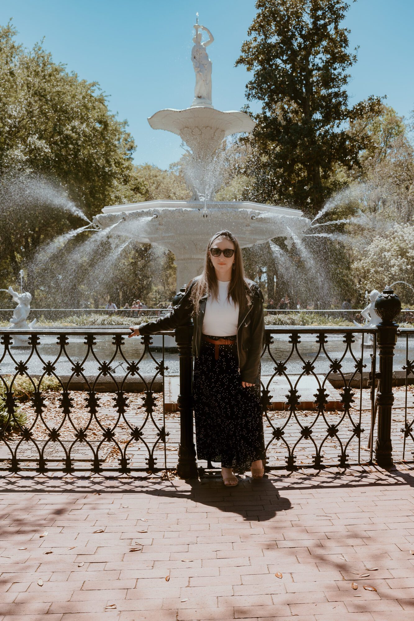 A woman standing in front of a fountain. 