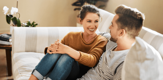 A couple talking on the couch.