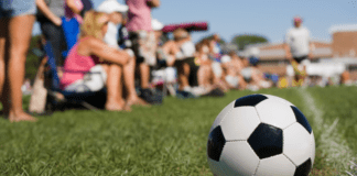 In My Sports Mom Era Parents sitting on the sidelines at a soccer game.