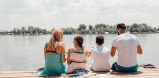 Fun and Affordable Things to Try This Summer A family sitting on a dock in summer.