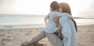 Change Can Be Hard and That’s Okay A woman holding her toddler on the beach.