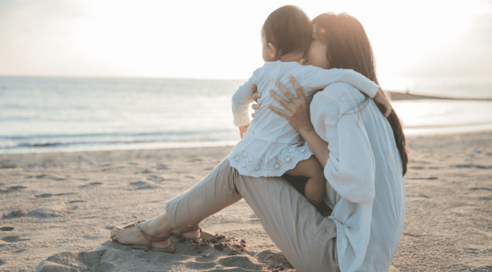 Change Can Be Hard and That’s Okay A woman holding her toddler on the beach.