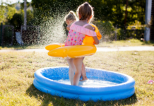 A girl playing in a kiddie pool.