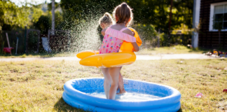 A girl playing in a kiddie pool.