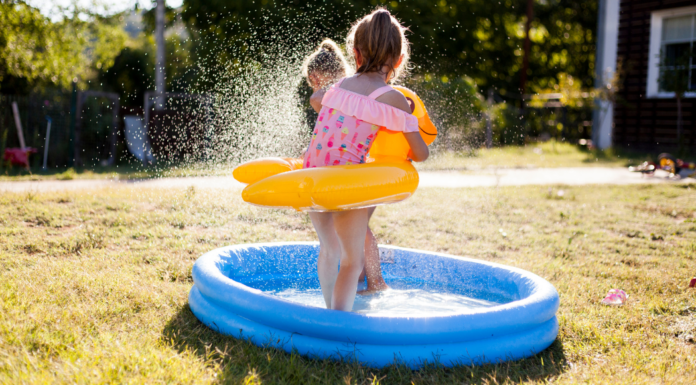 7 Easy Ways To Keep Your Kids Engaged This Summer A girl playing in a kiddie pool.