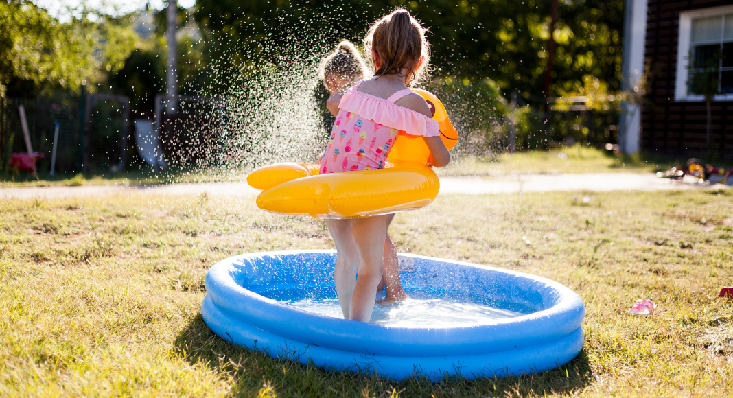 A girl playing in a kiddie pool.