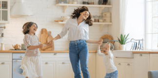 Living La Dolce Vita A woman laughing and dancing with her children in the kitchen.