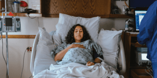 Expecting? Top 10 Tips Doulas Want You to Know A woman laying in a hospital bed in labor.