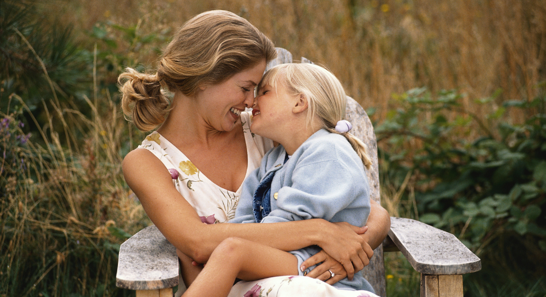 A mom kissing her daughter's nose.
