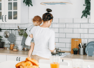 Single Moms Are Doing It All A single mom holding her baby trying to make breakfast.
