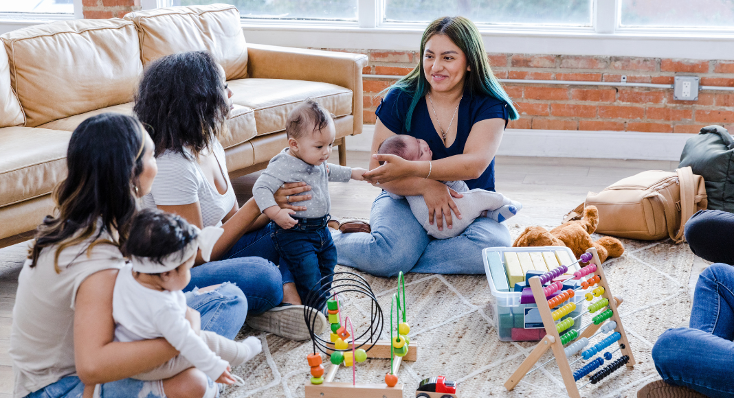 Women at a moms' group with their children. 