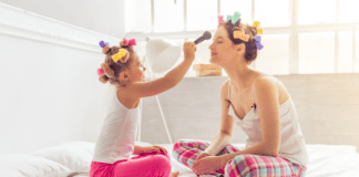 A girl putting makeup on her mom.