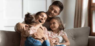 A family on the couch embracing.