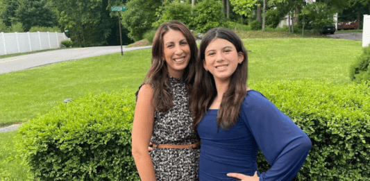 A mom and daughter posing in the latest style.