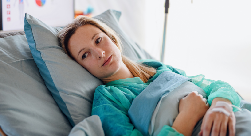 A woman in a hospital bed. 