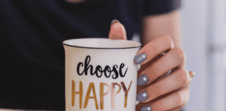 A Year of Intention Holding a mug that says "choose happy."
