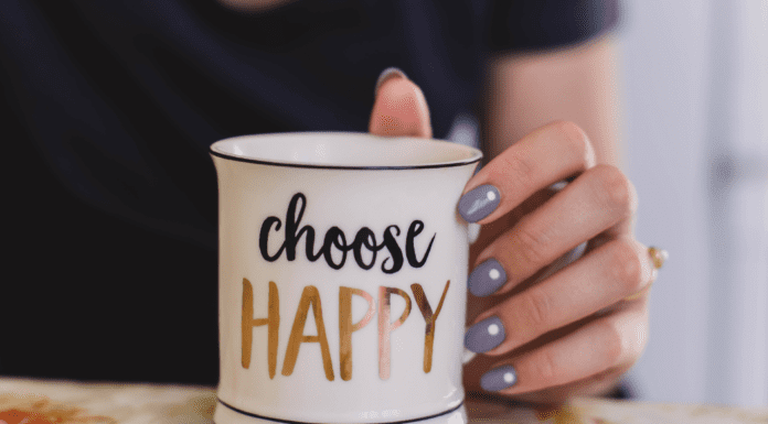 A Year of Intention Holding a mug that says "choose happy."