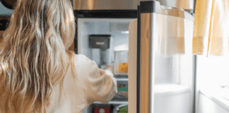 Please Don’t Ask What’s For Dinner A woman looking in the refrigerator.