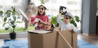 Kids pretending a cardboard box is a pirate ship.