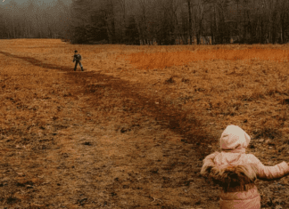 Children hiking on a muddy field.
