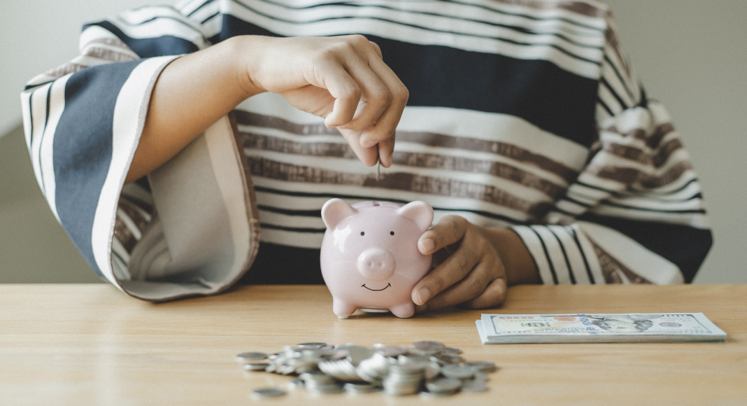 Putting money in a piggy bank.