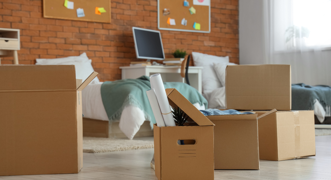 A college dorm room with boxes ready for someone to move in. 