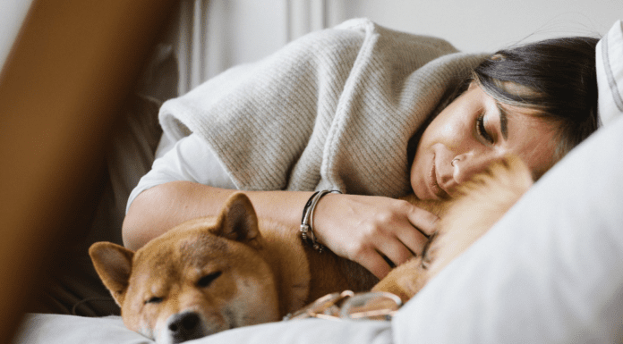 A woman laying down with her dog.