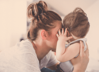 A mother kissing her baby.