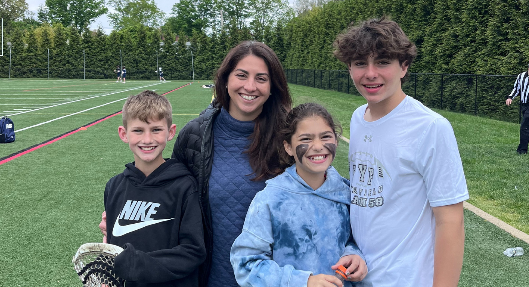A Type A/B mom with her children on a lacrosse field. 
