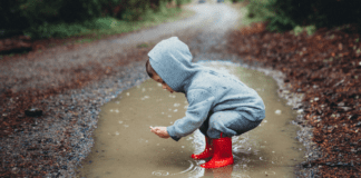 When In Doubt, Get Out A boy playing in a giant puddle.