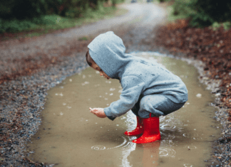 When In Doubt, Get Out A boy playing in a giant puddle.
