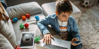 A boy on his computer and phone.