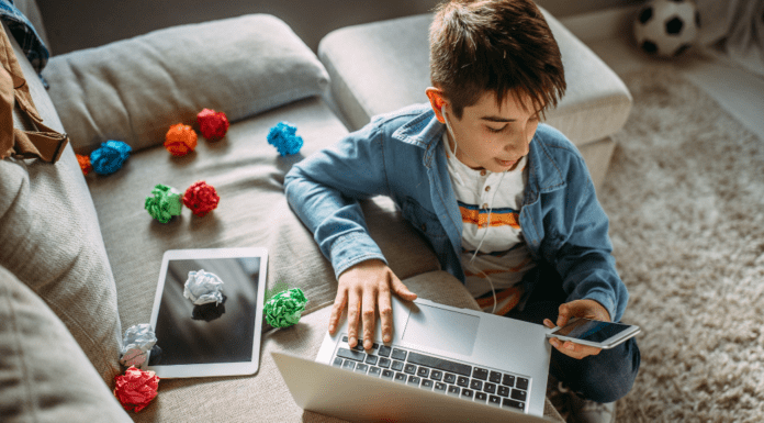 A boy on his computer and phone.
