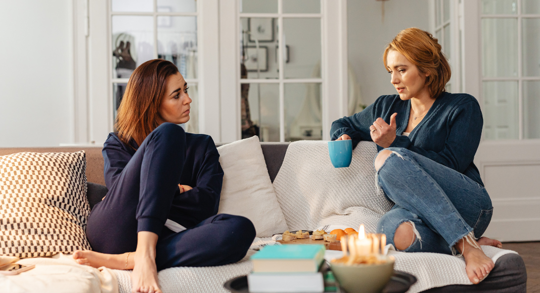Two women talking on the couch.