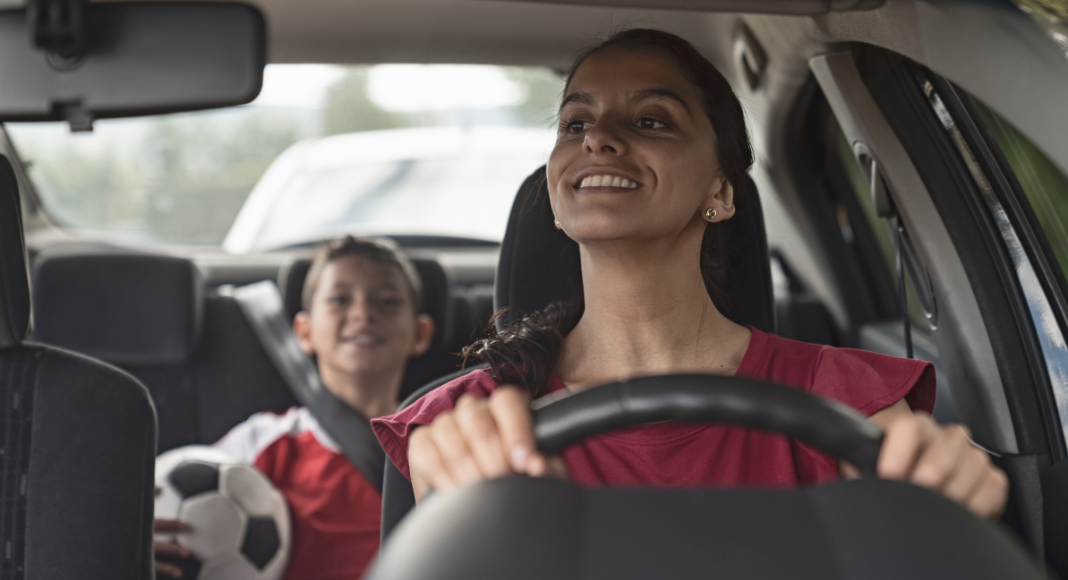 A mom driving her son to soccer practice. 