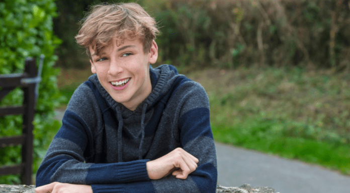 Why Tourette Syndrome Awareness Month Matters to Me A boy leaning on a fence.