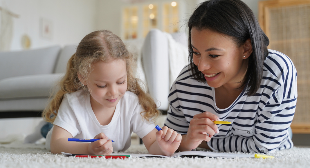 An au pair teaching a little girl.