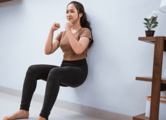 Get Fit Without a Gym A woman doing a wall-sit to get fit without the gym.