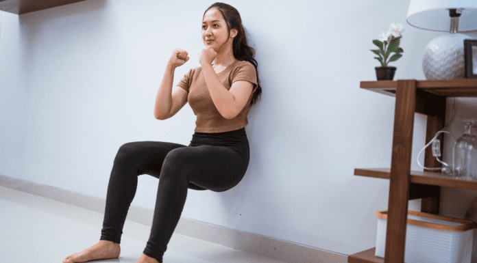 Get Fit Without a Gym A woman doing a wall-sit to get fit without the gym.