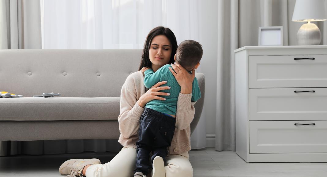 A stressed mom hugging her son.