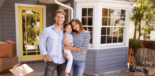 A family standing outside of their new home.